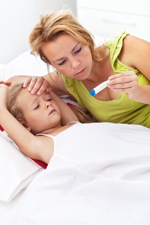 mother with thermometer taking temperature of daughter