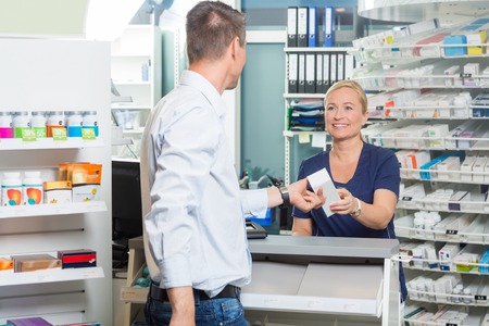 pharmacist giving prescription to patient