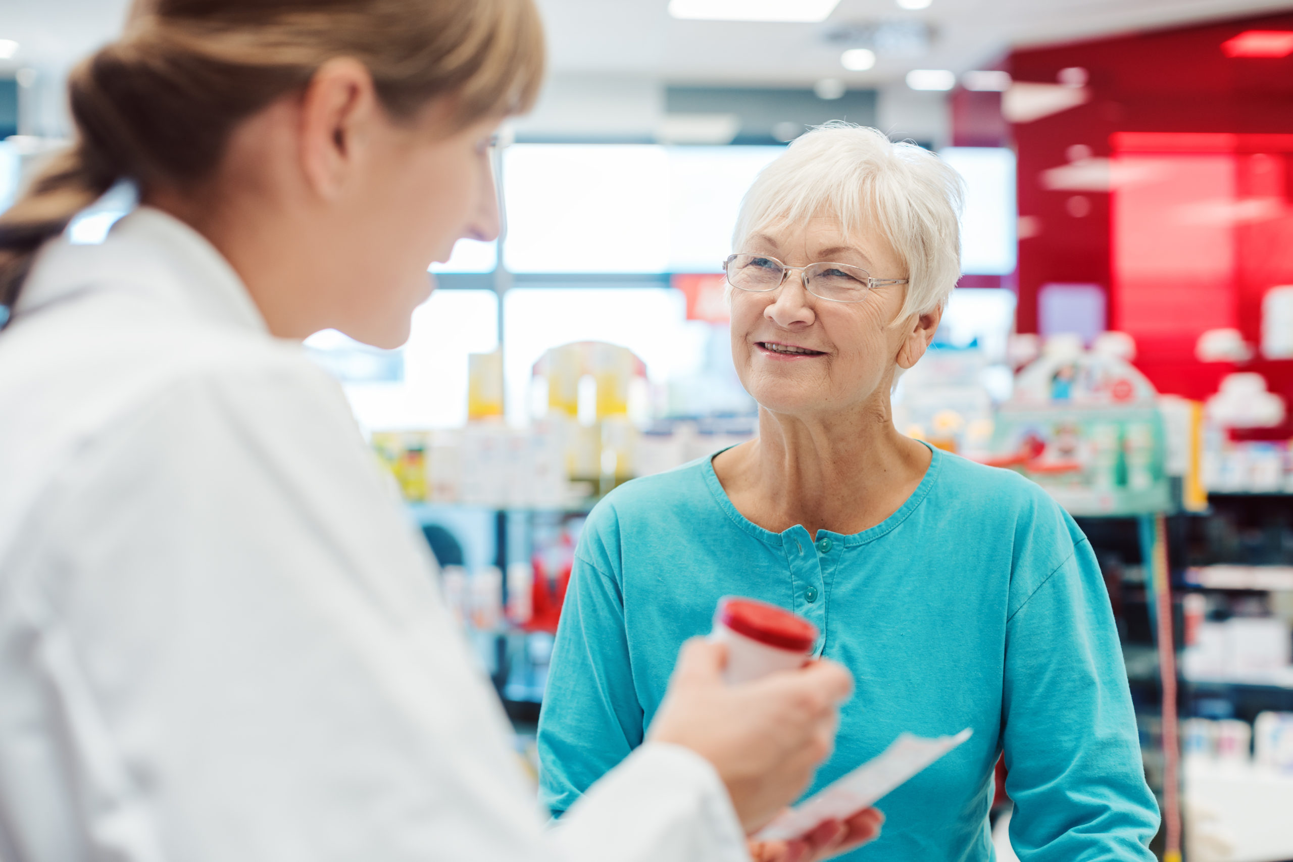 Senior woman in pharmacy talking to the chemist or pharmacist explain how long does costco hold prescriptions