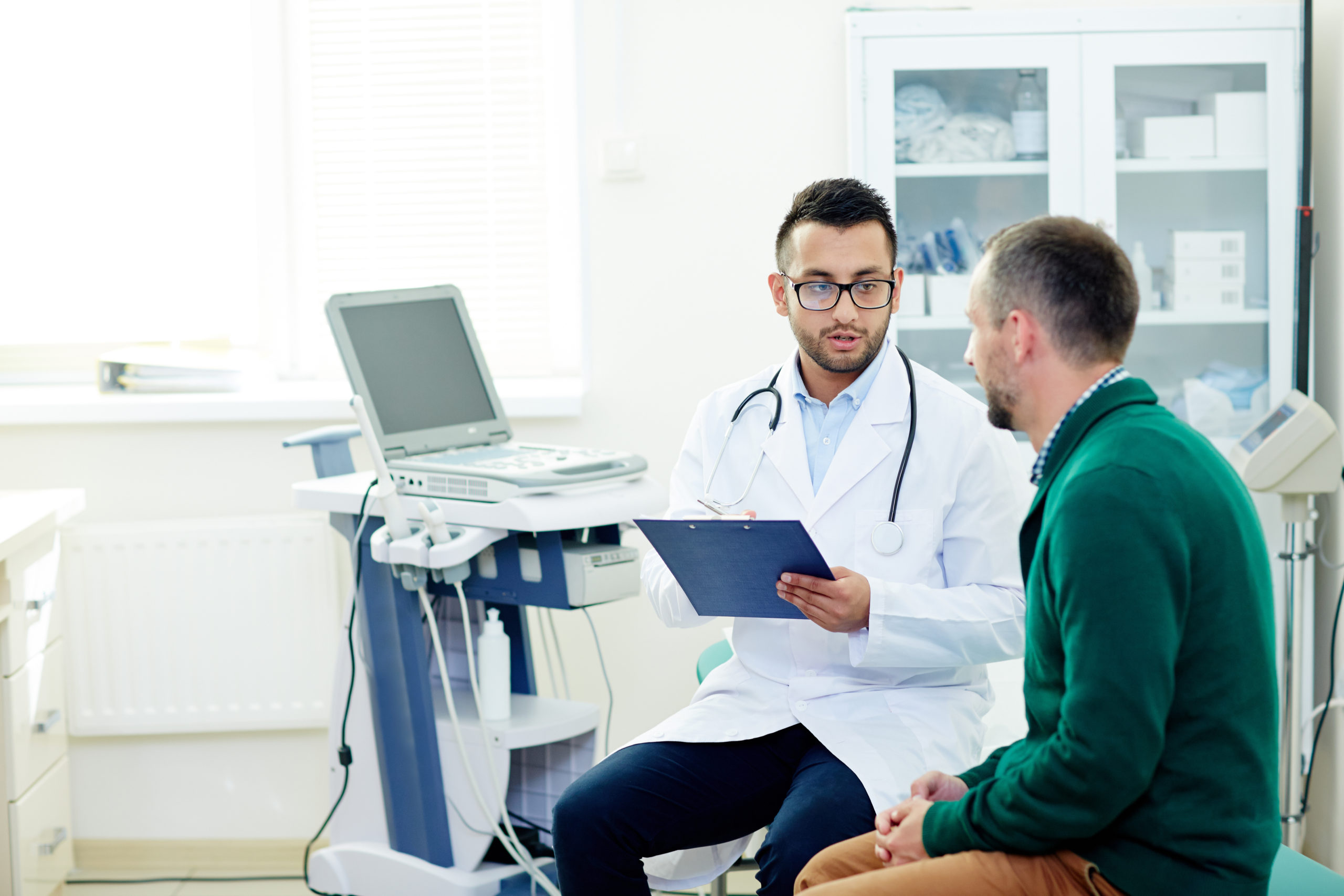 Middle-aged man talking to his physician at a modern office