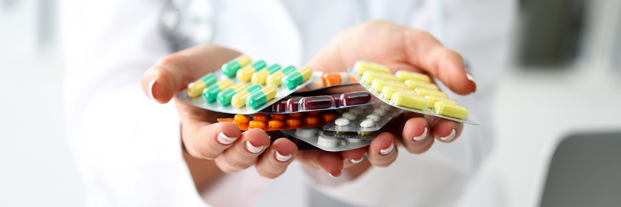 Doctor holding an assortment of antihistamine medications for treating cat allergies