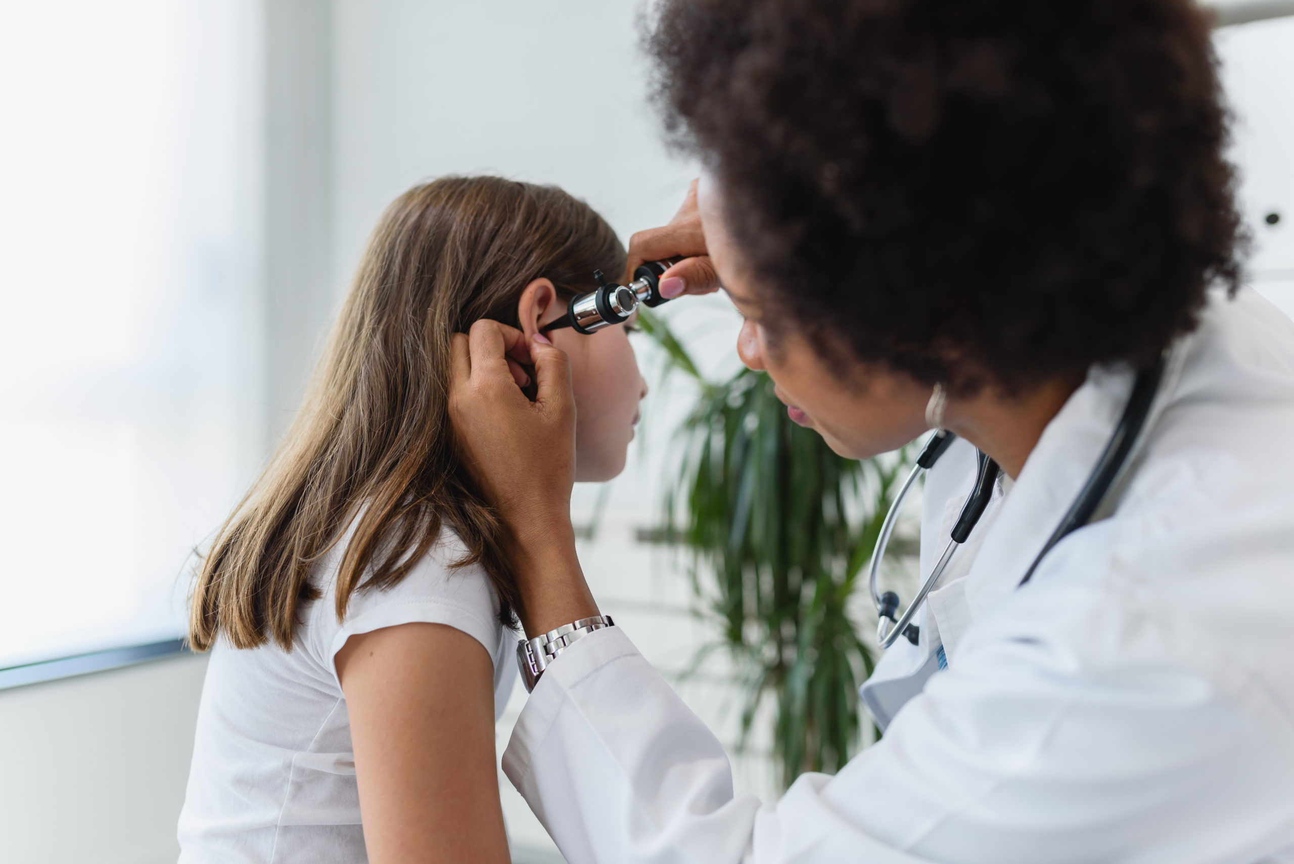 doctor examining young girl's ear to prescribe the best antibiotic for ear infection treatment